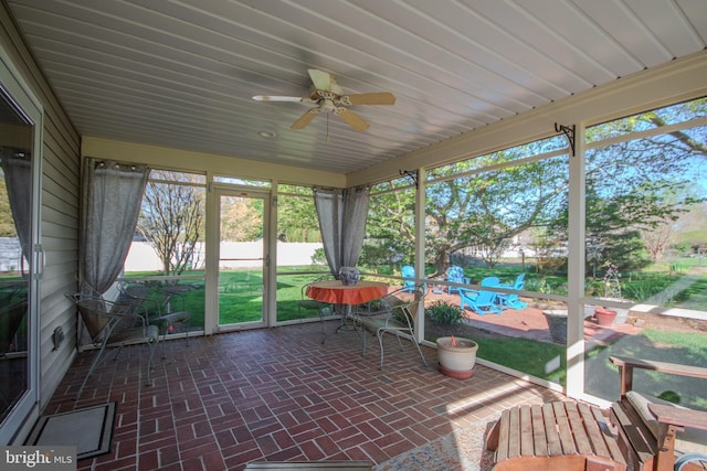 sunroom / solarium featuring a ceiling fan and plenty of natural light