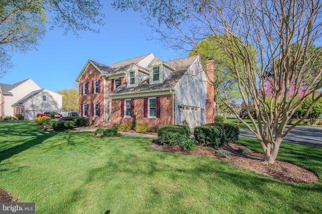 view of front facade featuring a chimney, a front yard, and brick siding