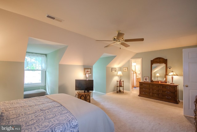 carpeted bedroom featuring lofted ceiling, visible vents, and a ceiling fan