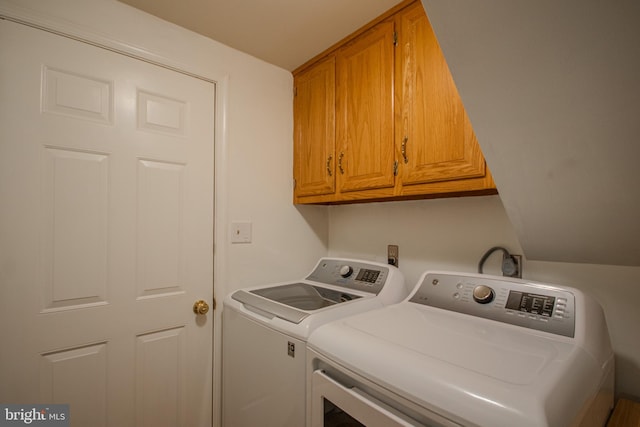 clothes washing area with washer and clothes dryer and cabinet space