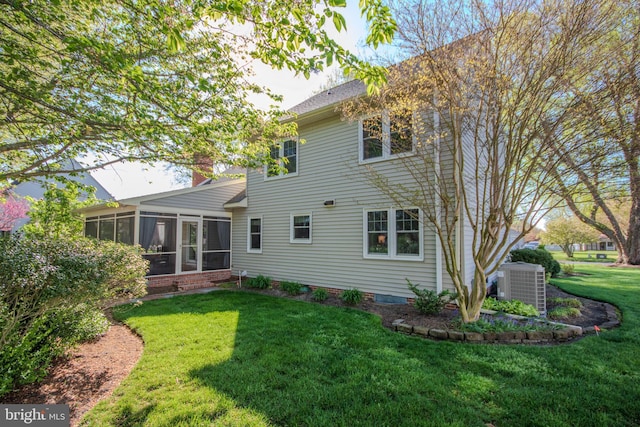 back of house with central AC, a sunroom, and a lawn