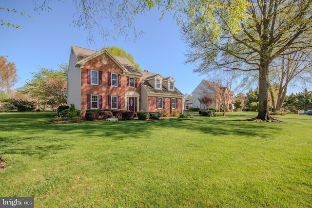 view of front of house with a front yard and brick siding