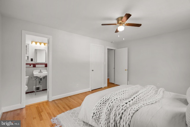 bedroom featuring connected bathroom, a ceiling fan, baseboards, and wood finished floors