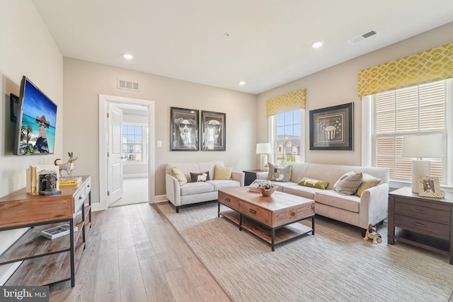 living area featuring wood finished floors, visible vents, and plenty of natural light