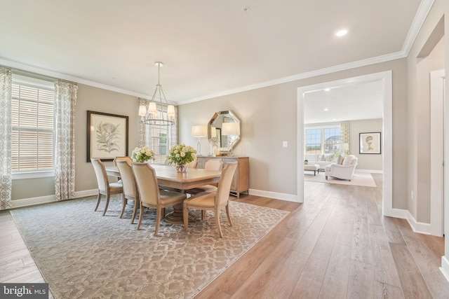 dining area featuring baseboards, ornamental molding, and light wood finished floors