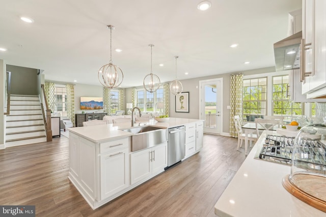 kitchen featuring recessed lighting, dishwasher, light countertops, and a sink