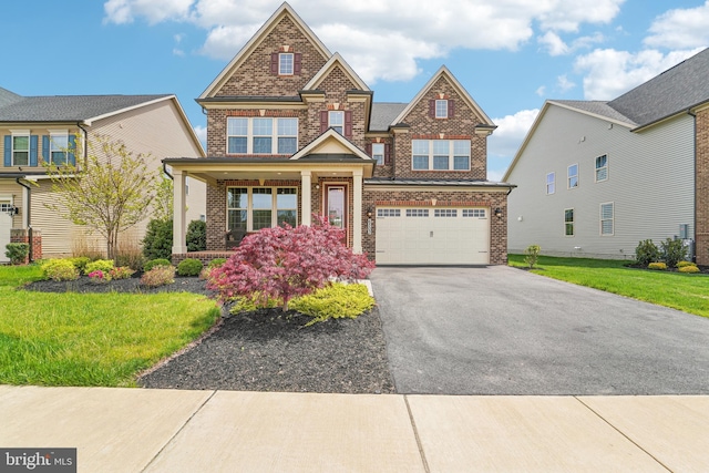 craftsman inspired home featuring a front lawn, a garage, brick siding, covered porch, and aphalt driveway