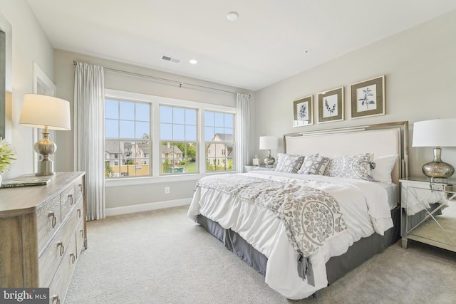 bedroom with visible vents, light carpet, recessed lighting, and baseboards