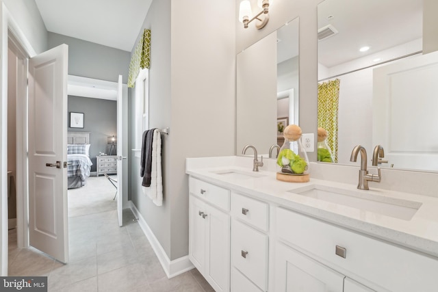 ensuite bathroom with double vanity, visible vents, tile patterned flooring, and a sink