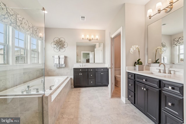 bathroom with visible vents, toilet, a bath, and a sink