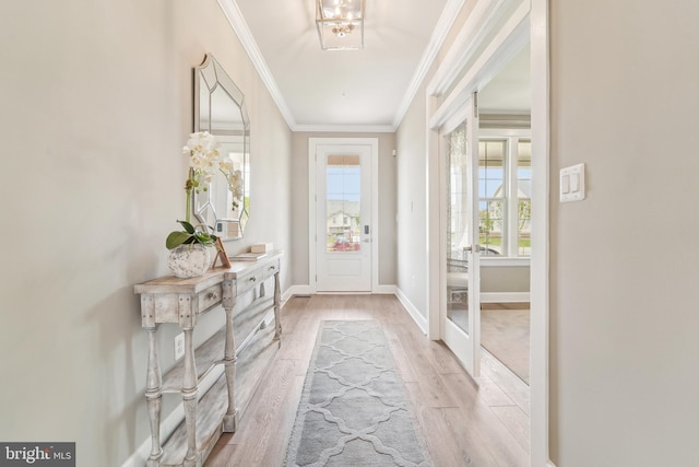 entryway featuring light wood-style floors, crown molding, and baseboards