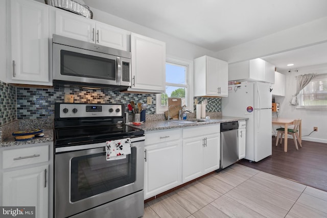 13432 Forest Glen Rd, Woodbridge, VA 22191 - kitchen with plenty of natural light, white cabinetry, appliances with stainless steel finishes, and tasteful backsplash