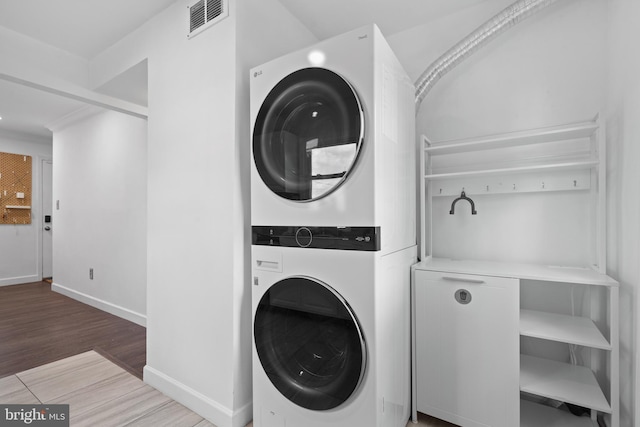 13432 Forest Glen Rd, Woodbridge, VA 22191 - washroom featuring stacked washer / drying machine, laundry area, light wood-style flooring, baseboards, and visible vents