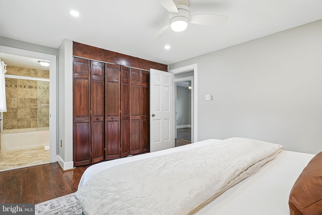 bedroom with baseboards, recessed lighting, connected bathroom, a ceiling fan, and dark wood finished floors
