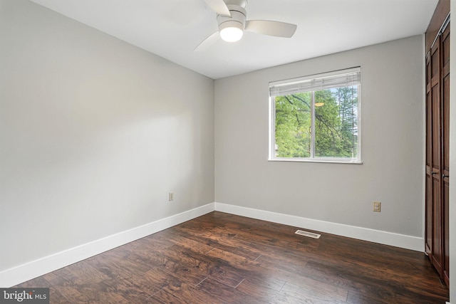 unfurnished bedroom featuring baseboards, dark wood finished floors, ceiling fan, and visible vents