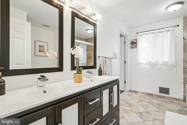 full bath with a sink, double vanity, and visible vents