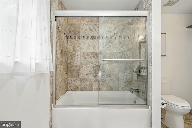 bathroom with enclosed tub / shower combo, toilet, and visible vents