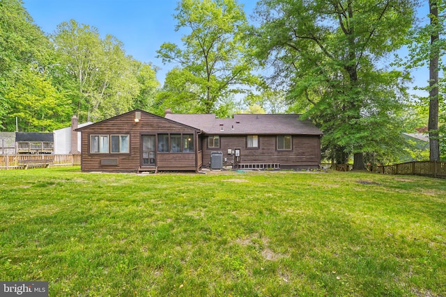 rear view of house featuring a yard, fence, cooling unit, and a sunroom