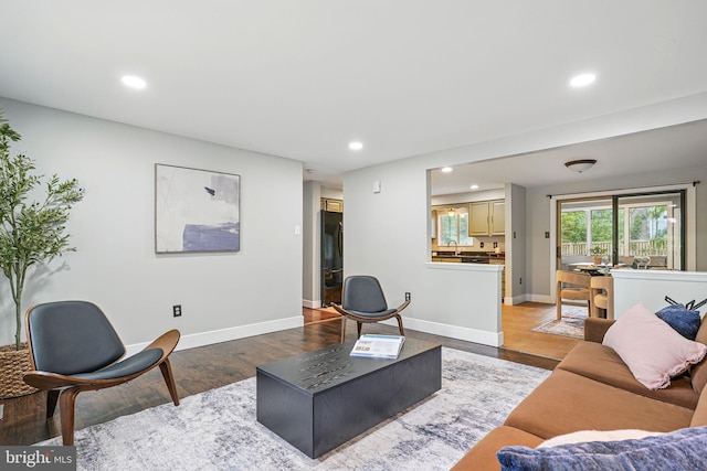 living area with recessed lighting, light wood finished floors, and baseboards