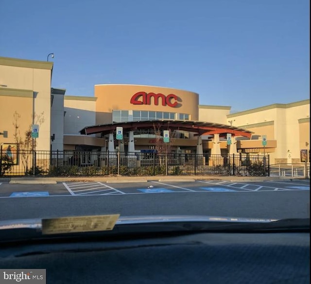 view of building exterior featuring uncovered parking and fence