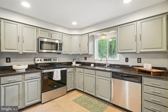kitchen featuring a sink, gray cabinetry, dark stone countertops, stainless steel appliances, and recessed lighting