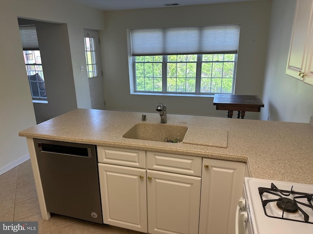 kitchen featuring stainless steel dishwasher, gas range gas stove, a sink, light tile patterned flooring, and white cabinetry