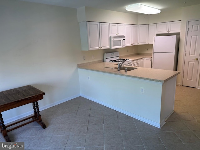 kitchen featuring a peninsula, white appliances, baseboards, light countertops, and white cabinets