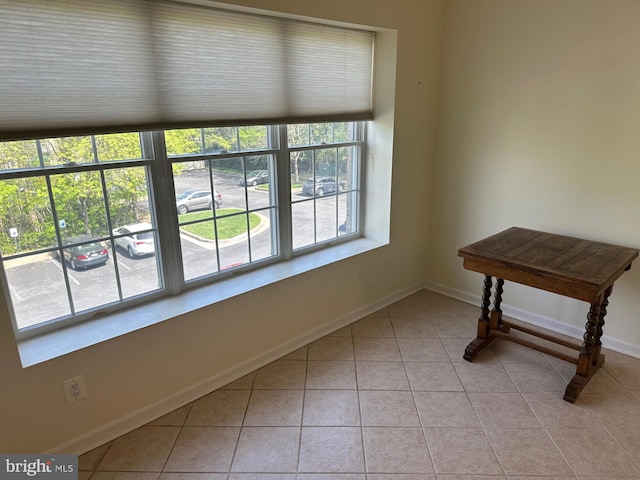 interior space featuring baseboards, light tile patterned floors, and a healthy amount of sunlight