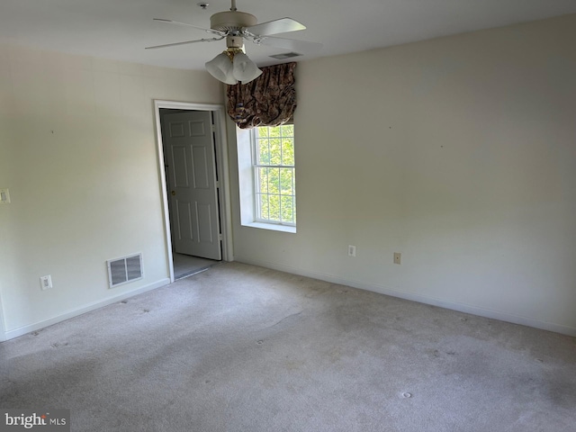 spare room featuring carpet flooring, a ceiling fan, baseboards, and visible vents