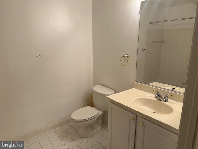 bathroom featuring vanity, baseboards, tile patterned floors, and toilet