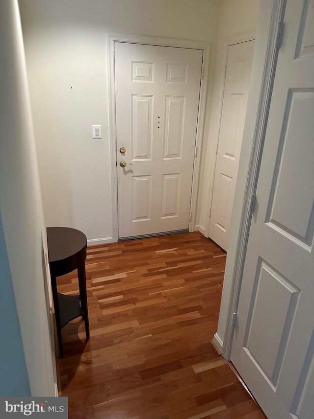 corridor with baseboards and light wood-type flooring