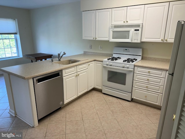 kitchen with a sink, white cabinets, white appliances, and light tile patterned flooring