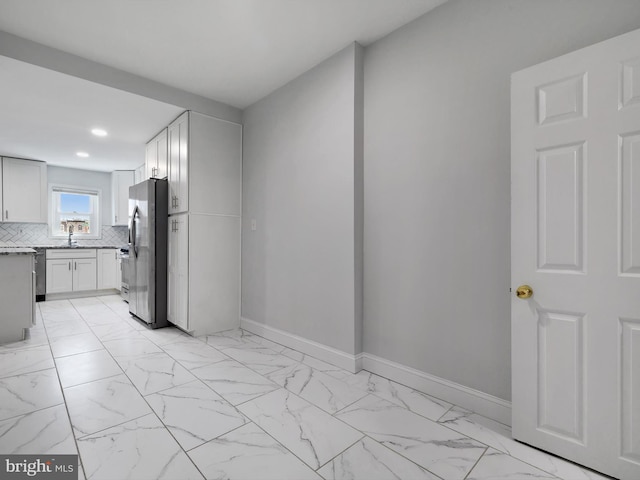 interior space with recessed lighting, freestanding refrigerator, light countertops, marble finish floor, and baseboards