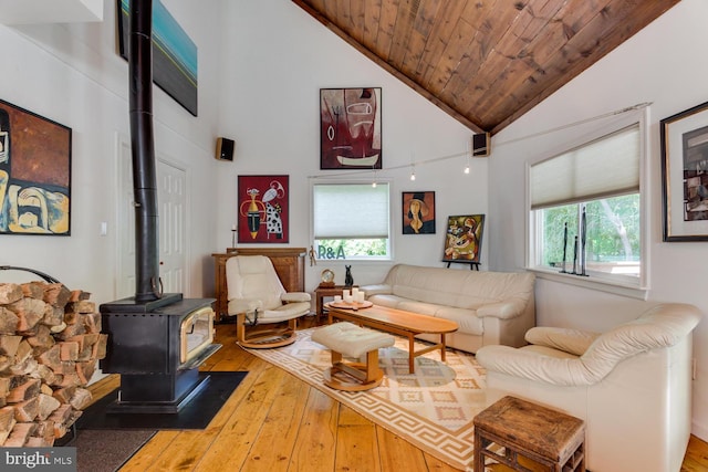 living area with hardwood / wood-style flooring, wooden ceiling, a wood stove, and high vaulted ceiling
