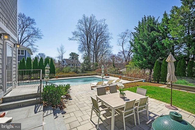 view of swimming pool with a fenced in pool, outdoor dining space, and a patio area