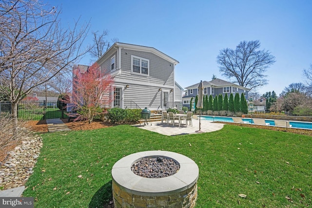 rear view of house featuring a fenced in pool, fence, a lawn, and a patio area