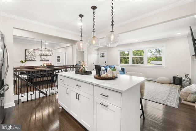 kitchen with open floor plan, dark wood finished floors, a kitchen island, and light countertops