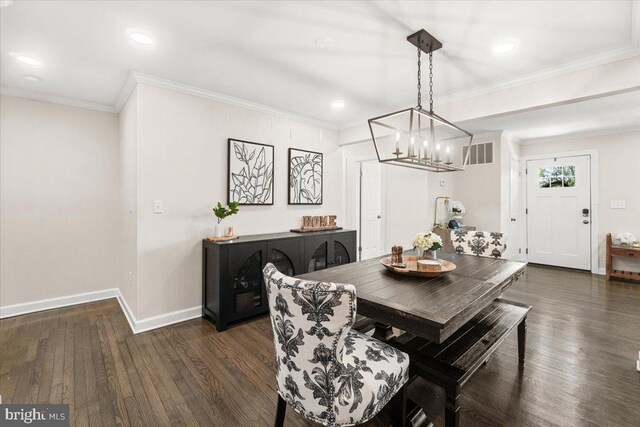 dining space with visible vents, ornamental molding, an inviting chandelier, and dark wood-type flooring