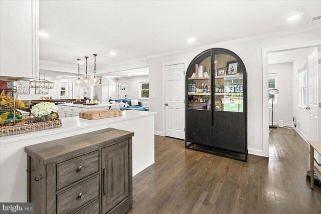 entryway with dark wood-type flooring, recessed lighting, and ornamental molding