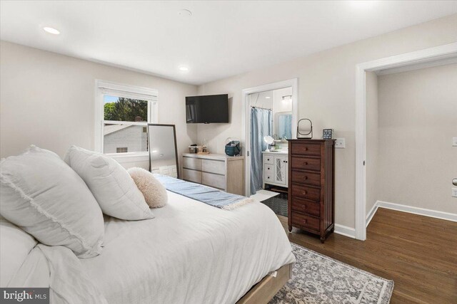 bedroom with baseboards, recessed lighting, dark wood finished floors, and ensuite bath