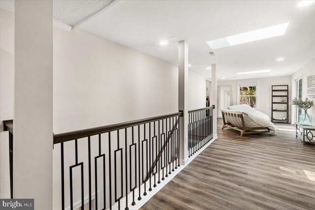 hall with visible vents, a skylight, wood finished floors, an upstairs landing, and recessed lighting