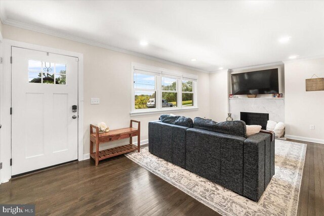 living area featuring a premium fireplace, recessed lighting, baseboards, dark wood-type flooring, and ornamental molding