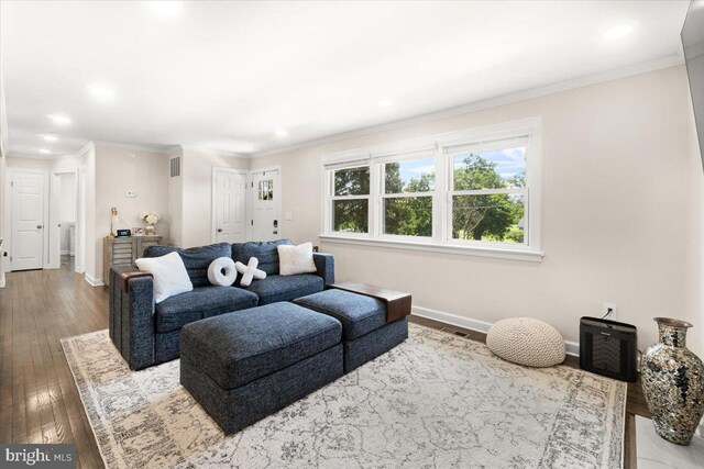 living area featuring baseboards, ornamental molding, hardwood / wood-style flooring, and visible vents