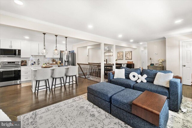 living room featuring recessed lighting, ornamental molding, and wood finished floors