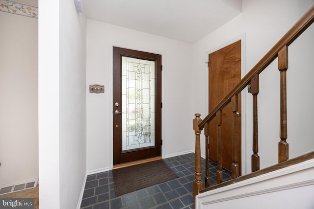 tiled foyer entrance featuring visible vents, stairway, and baseboards