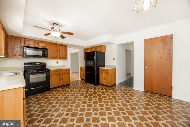 kitchen featuring brown cabinetry, light countertops, black appliances, ceiling fan, and a sink