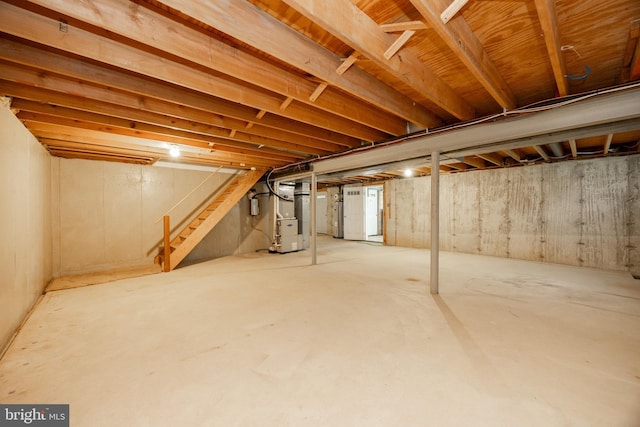 unfinished basement with heating unit and stairway