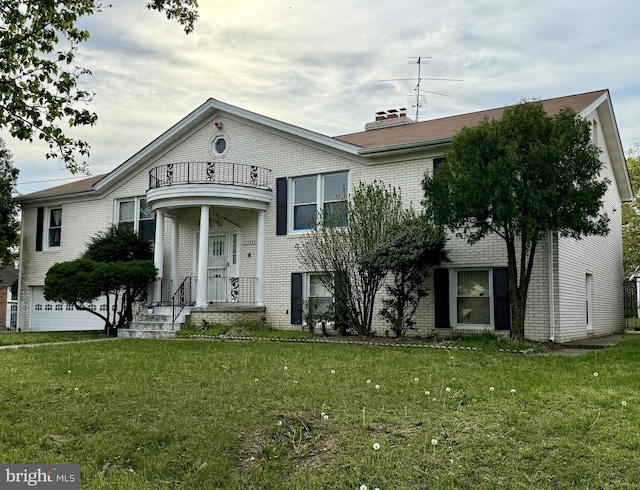 view of front of house with brick siding, a front lawn, and a balcony