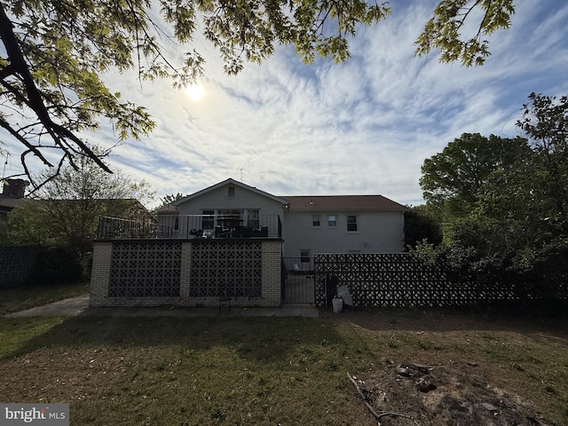rear view of house with brick siding and fence