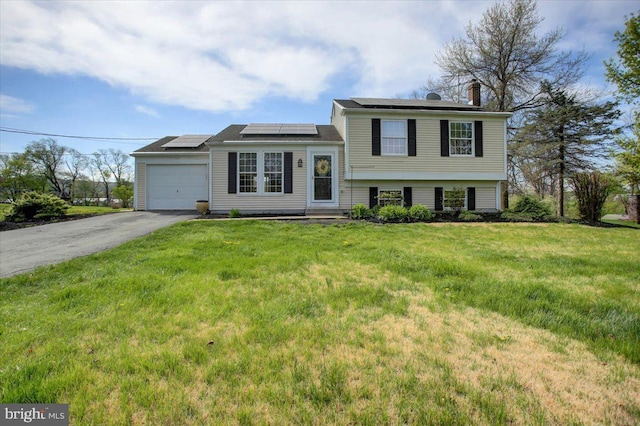 2284 Pine Rd, Newville, PA 17241 - tri-level home featuring a front lawn, solar panels, driveway, a chimney, and a garage